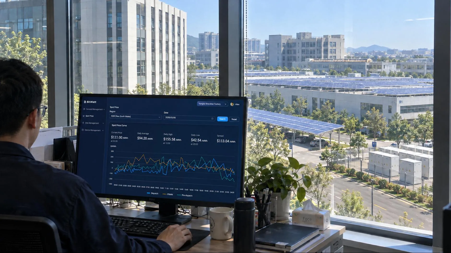 An operator monitoring the BitWatt platform overlooking a solar-roofed industrial park